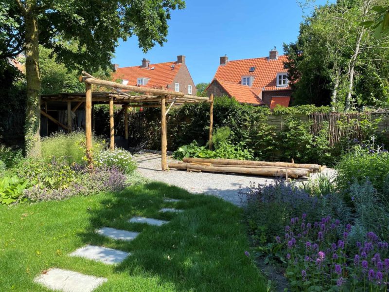 Haselnuss Zaun Somme 180 mit den Maßen 180 cm breit und 180 cm hoch als Zaun in einem grünen Garten.