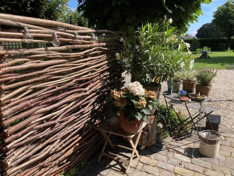 Haselnuss Zaun Somme 1 in der Größe 150 cm breit und 180 cm hoch als Gartenzaun bei einer Grillecke