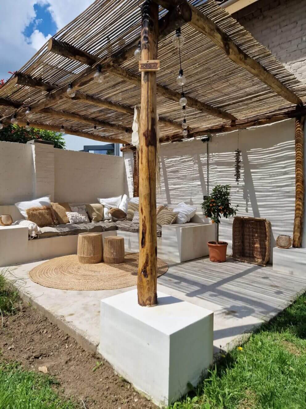 Sitzecke im Garten im Ibiza-Stil mit Holzpfählen aus Kastanie