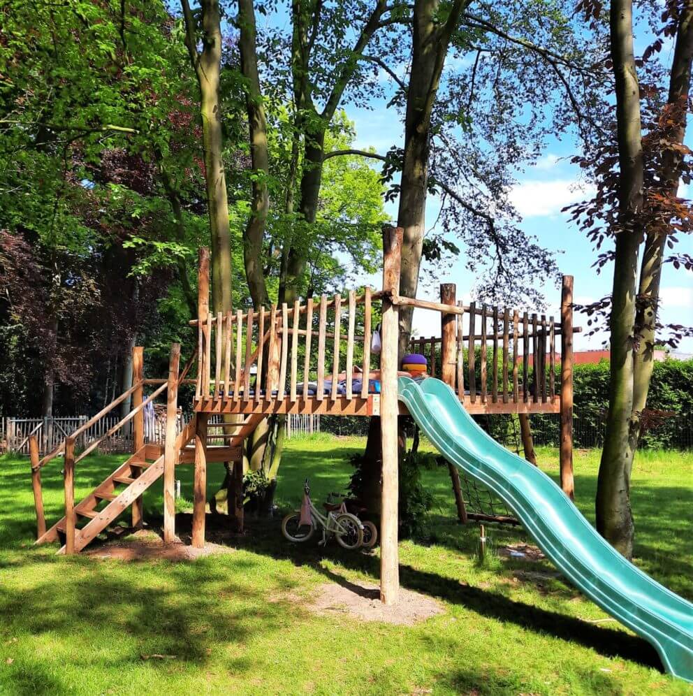 aire de jeux avec toboggan en bois de châtaignier de différentes tailles et de différents diamètres, terminé par des lattes à grille semi-circulaire - Adéquat