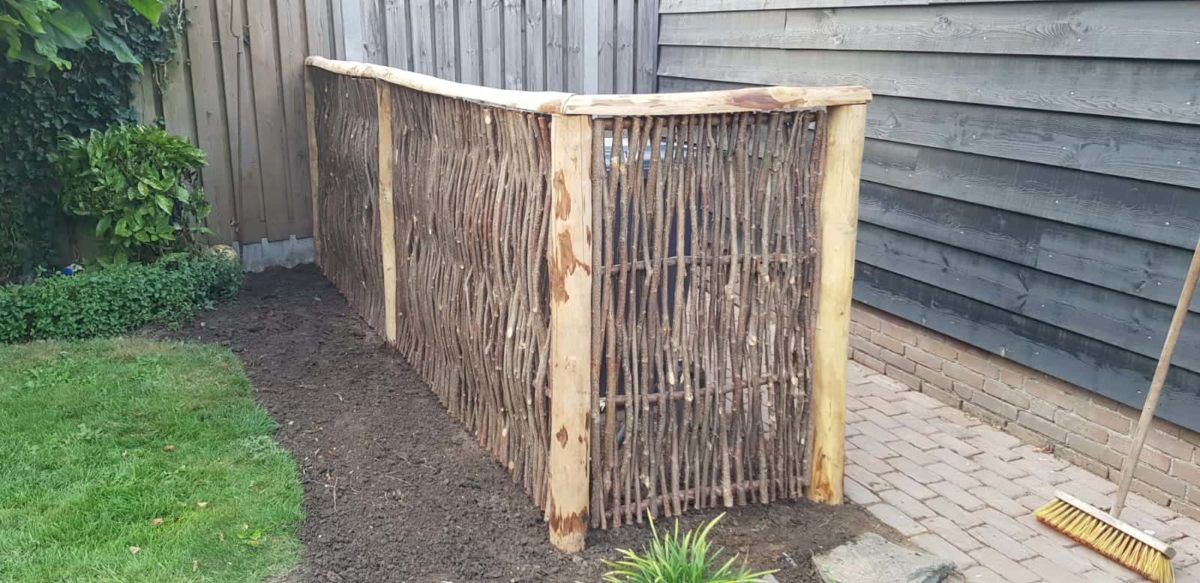 Un cache poubelles fait avec un brise-vue en noisetier tressé type Loire 2, 180 cm x 115 cm