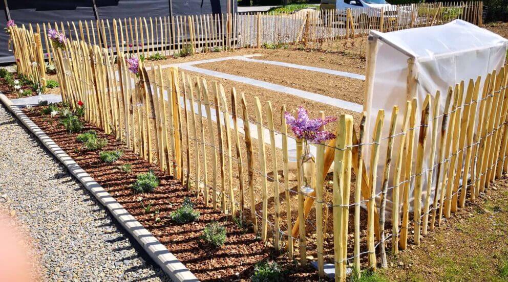 Clôture ganivielle française en bois de châtaignier de 100 cm de hauteur et avec un espacement de 8 cm. entre les lattes. Clôture autour du potager.