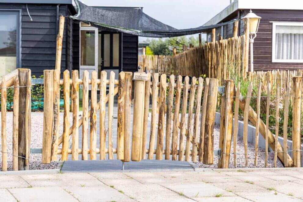 Clôture ganivielle française en bois de châtaignier de 100 cm de hauteur et avec un espacement de 6 cm. entre les lattes. Avec Portail français rondins châtaignier double 80 cm hauteur