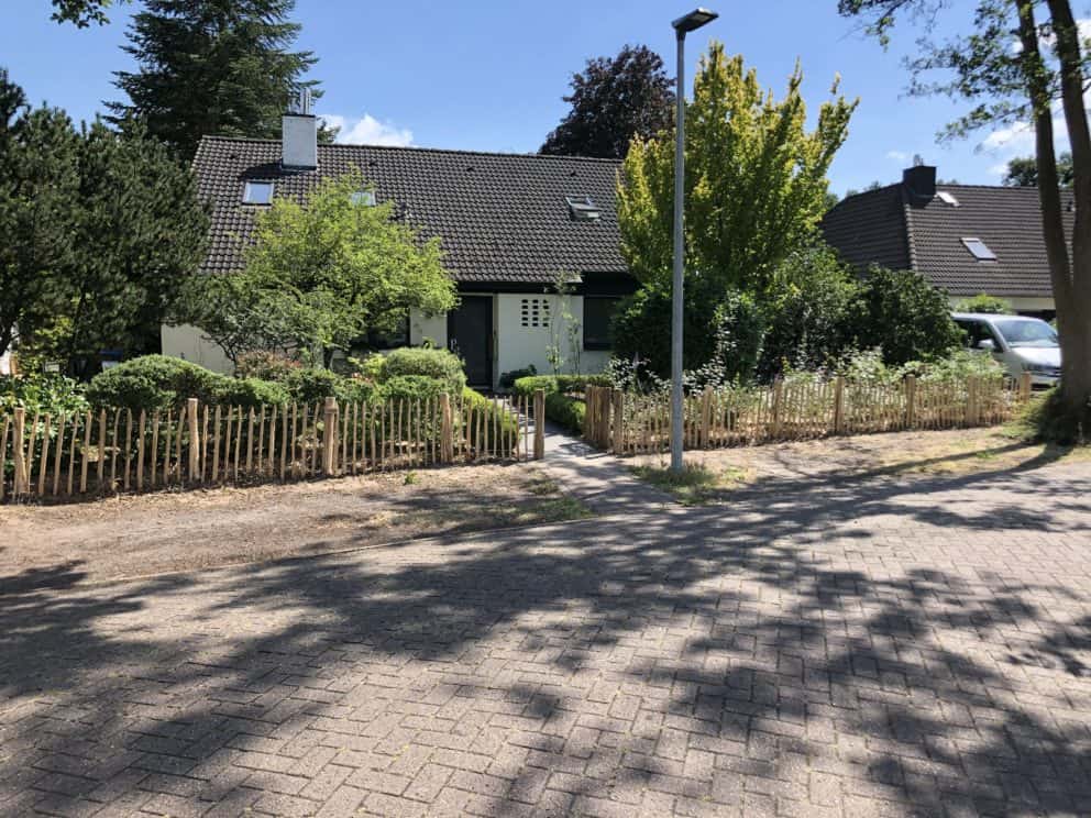 Schapenhek van 80 cm hoog met latafstand 6 cm en een raamwerkpoort van 100 cm breed bij 80 cm hoog als omheining en doorgang bij de voortuin van een huis.