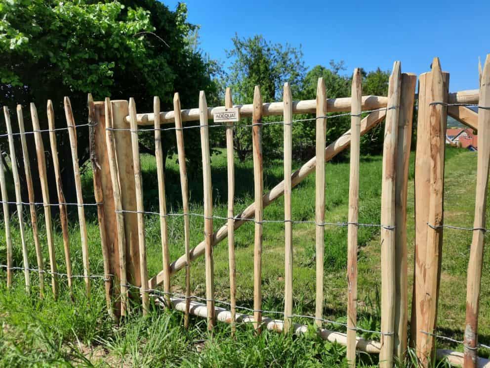 Kastanjehouten schapenhek van 120 cm hoog met een latafstand van 10 cm en een dubbele raamwerkpoort van 150 cm breed bij 120 cm hoog per poortdeel met hetzelfde schapenhek erop.