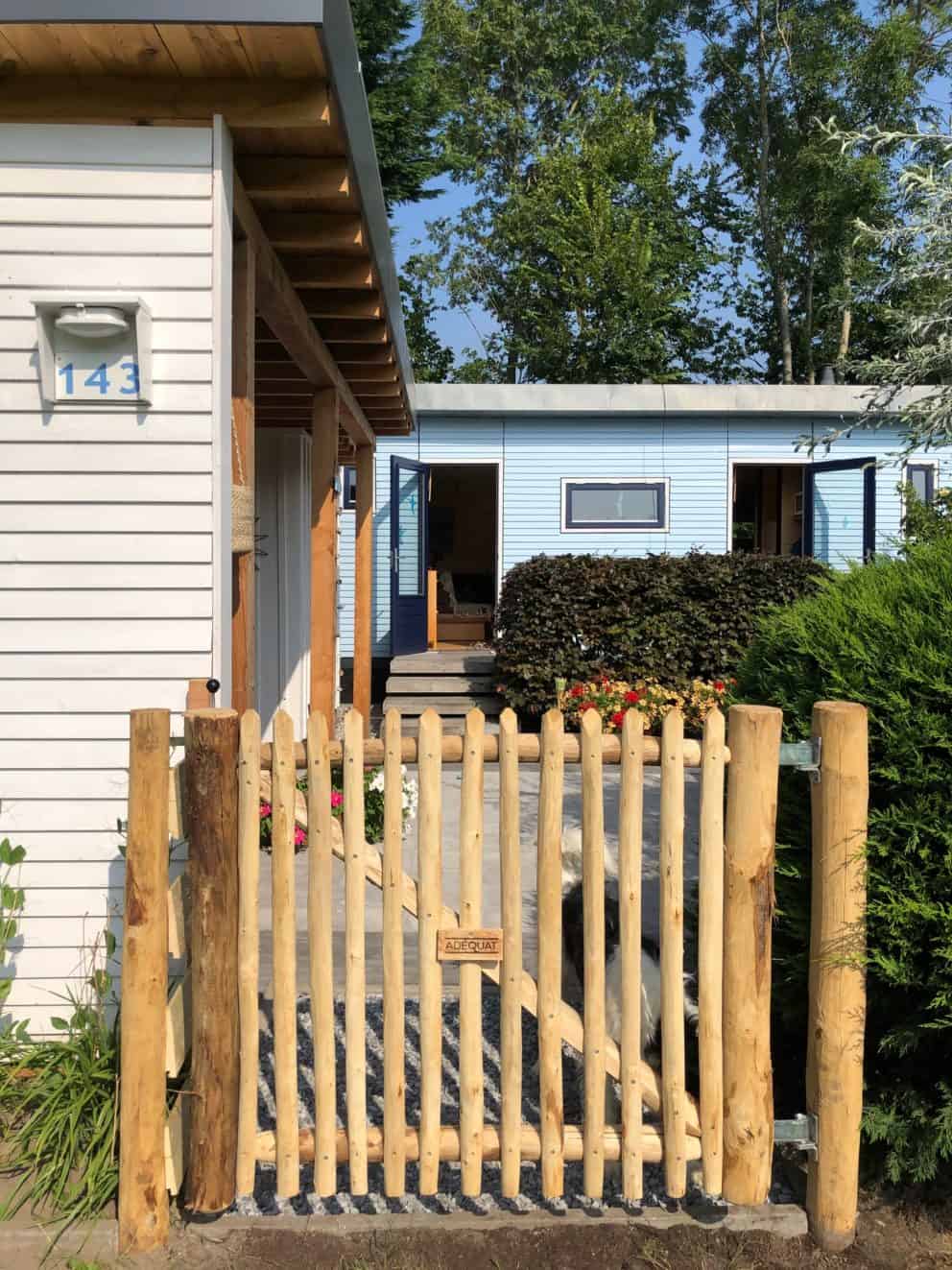 Franse rondhoutpoort van kastanjehout van 100 cm hoog en 120 cm breedmet een afmeting van 100 cm hoog bij 120 cm breed als doorgang naar de voortuin van een woning.