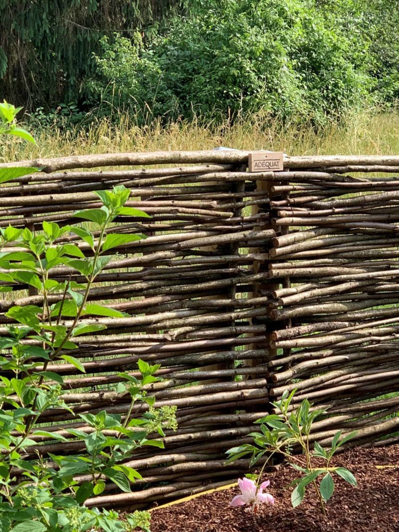 Hazelaarscherm Somme 3 als lage afrastering gebruikt in een tuin met een uitzicht over de bossen.