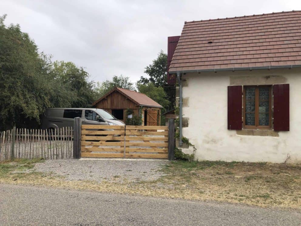 Eiken dubbele boerenlandhek op maat gemaakt. De poort staat rechts aan het huis vastgemaakt en dient als doorgang naar de parkeerplek en de achtertuin.