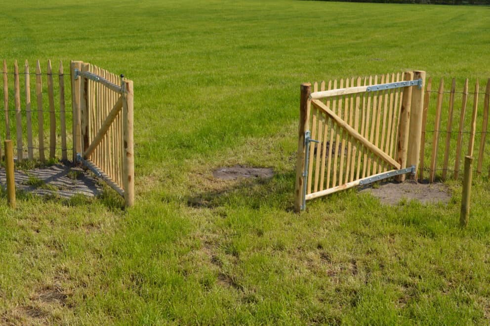 Franse dubbele rondhoutpoort van 100 cm hoog en 150 cm breed bevestigd aan schapenhek van 100 cm hoog.