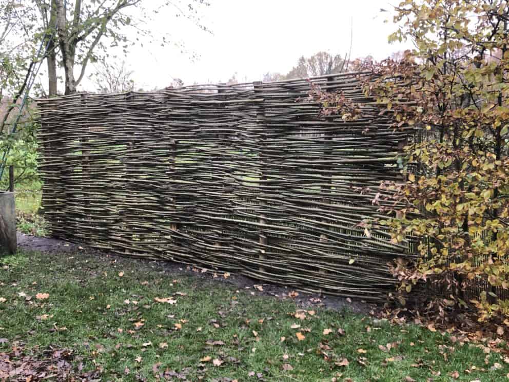 schutting gemaakt van wilgentenen met palen van kastanjehout