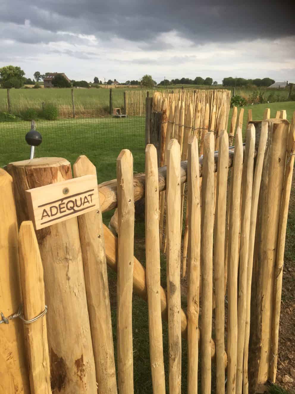 Frans schapenhek kastanje 120 cm hoog met een latafstand van 4 cm en een franse rondhoutpoort van 100 cm breed bij 120 cm hoog als omheining en doorgang in een tuin