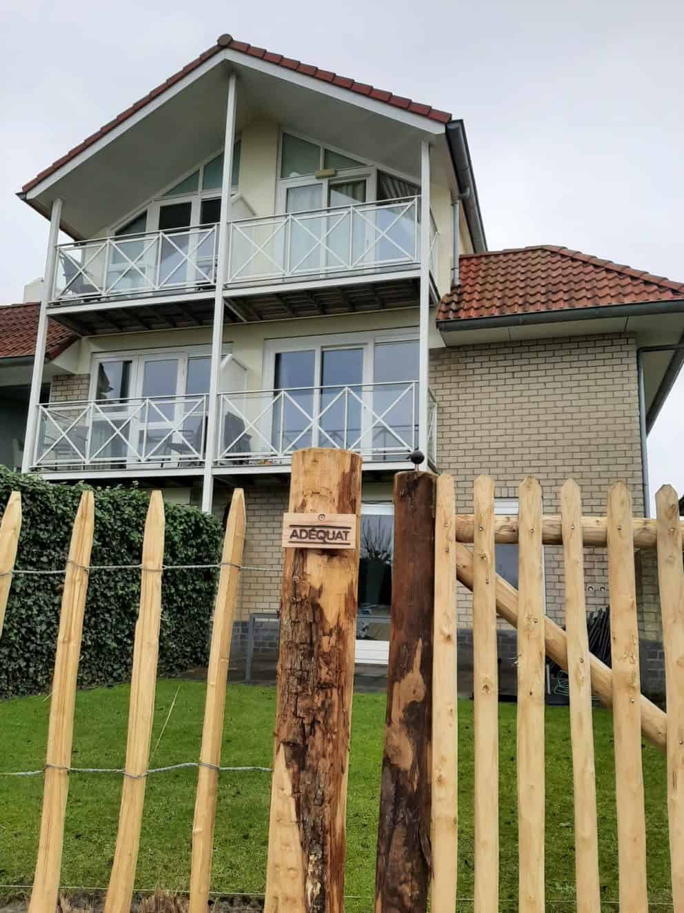 Franse rondhoutpoort van 120 cm breed bij 100 cm hoog geplaatst in een voortuin.