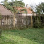 Schutting van hazelaarschermen Loire 2 180 cm breed en 115 cm hoog. Gebruikt in een groene tuin als afrastering.