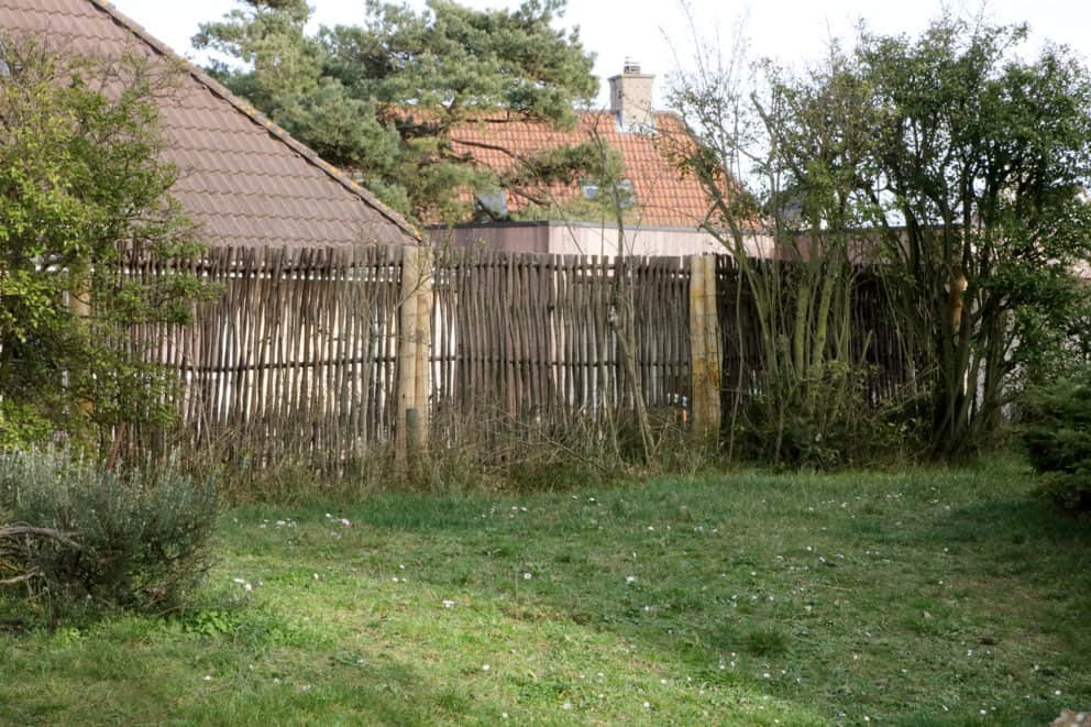 Schutting van hazelaarschermen Loire 2 180 cm breed en 115 cm hoog. Gebruikt in een groene tuin als afrastering.