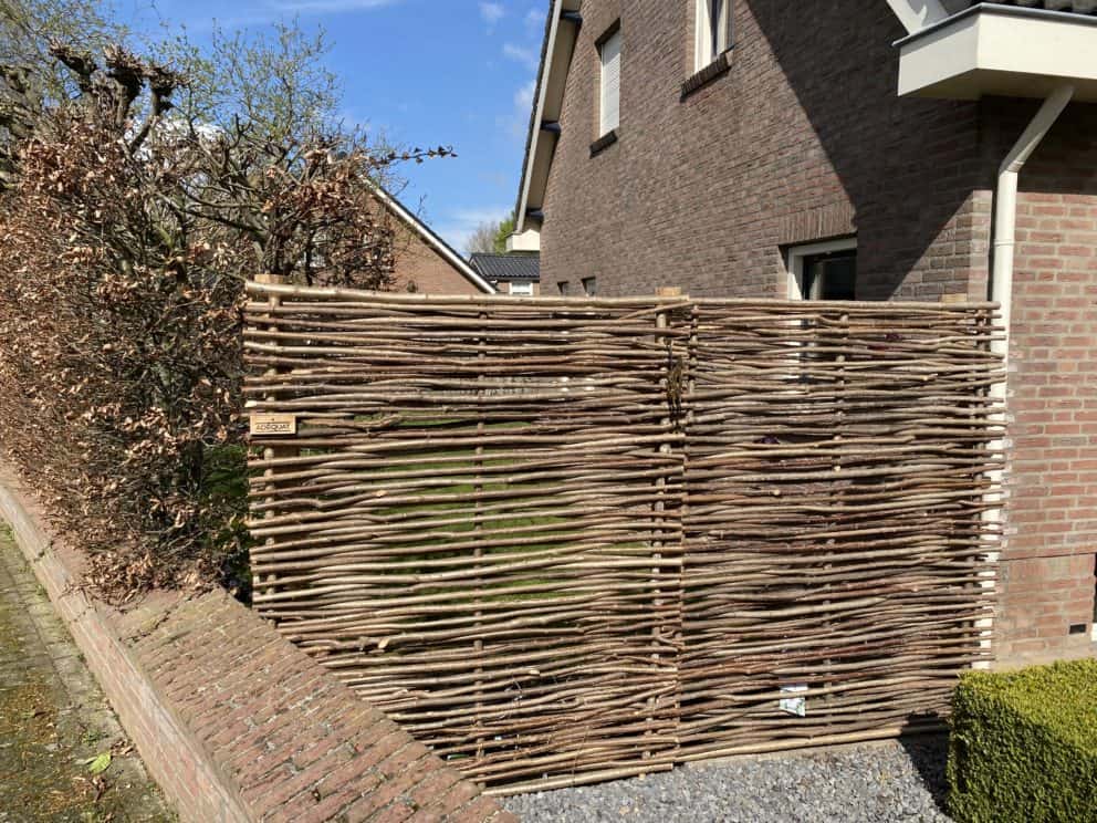 Hazelaarscherm Somme 1 van 180 cm hoog en 150 cm breed als afrastering tussen huis en muur.