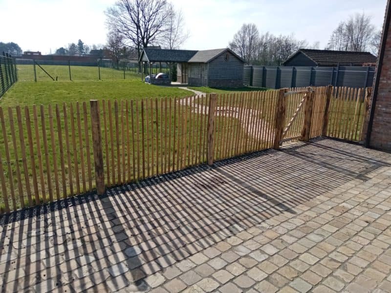 Franse rondhoutpoort van 100 cm breed en 120 cm hoog als afscheiding in de tuin tussen schapenhek geplaatst van robinia in de afmeting 120 cm met een latafstand van 4 cm