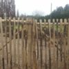 Dubbele franse rondhoutpoort van 200 cm hoog en 100 cm breed per poortdeel gebruikt als doorgang van en naar een tuin.