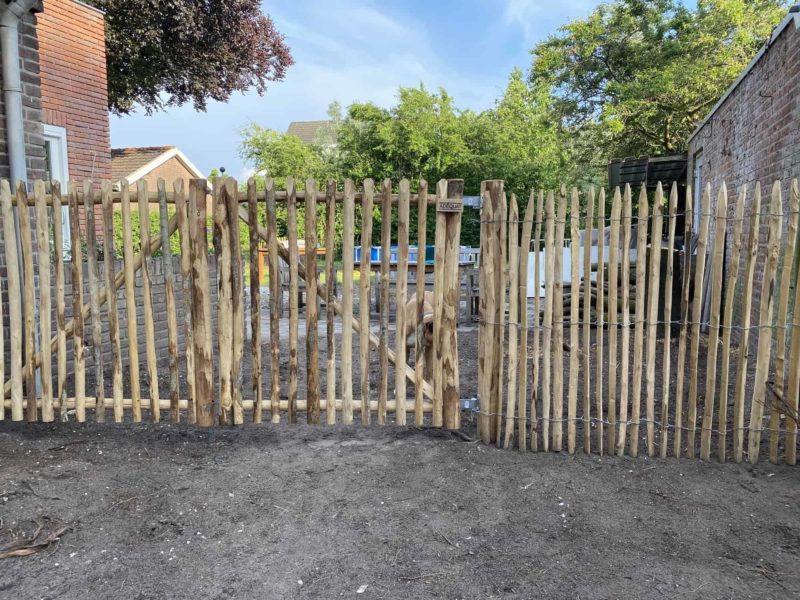 Dubbele Franse rondhoutpoort van 120 cm hoog en 120 breed per poortdeel gebruikt als afscheiding en toegang in de tuin.