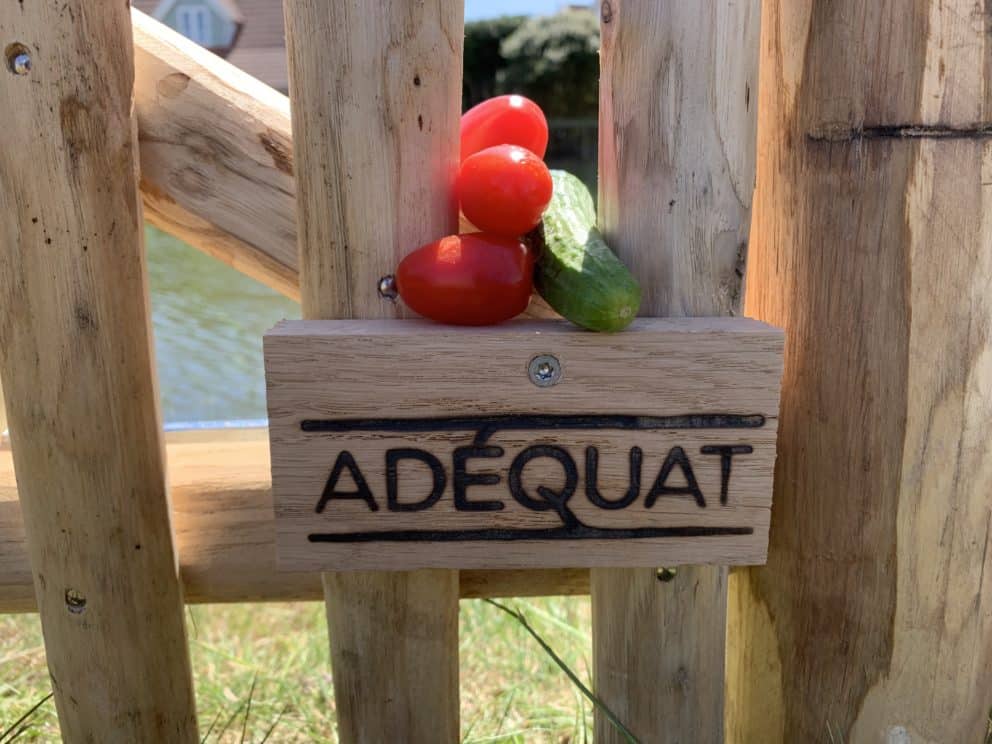 Close-up van de franse rondhoutpoort met een hoogte van 120 cm en een breedte van 80 cm gebruikt als toegang van de tuin naar het water.