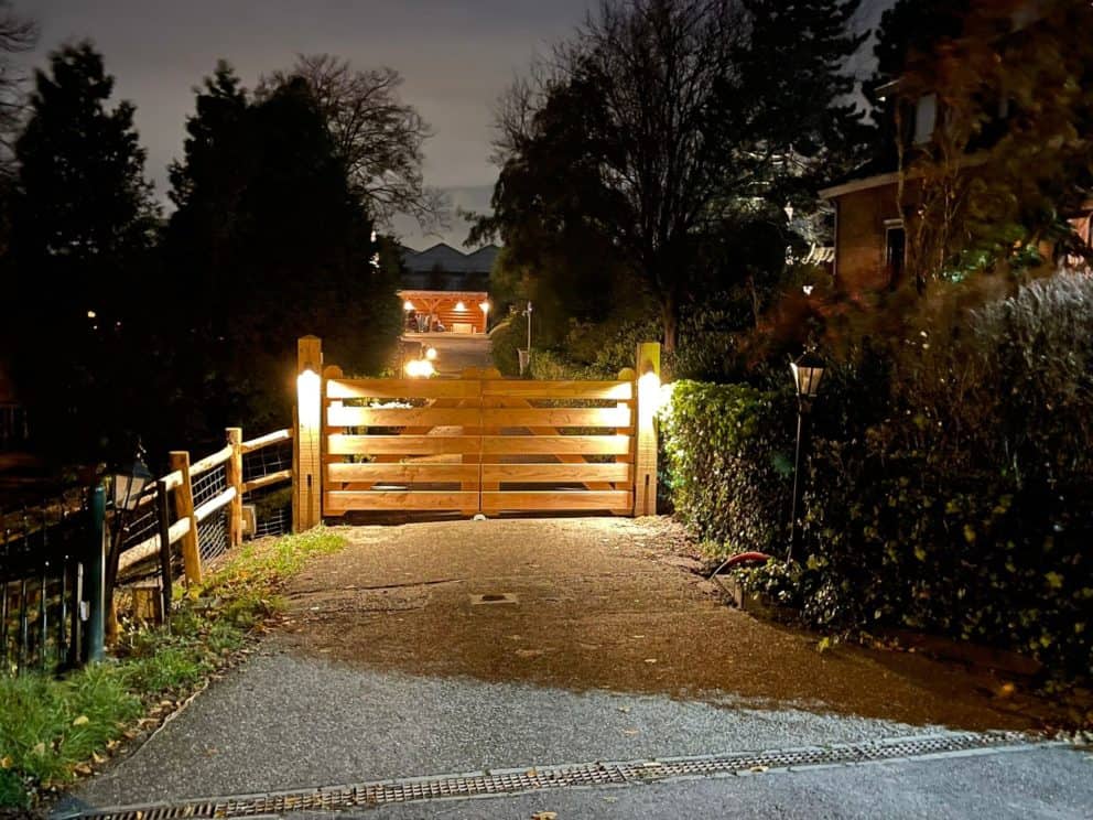 Douglas boerenlandhek van 150 cm hoog gebruikt bij een oprit met verlichting aan de poort. De poort opent elektrisch.