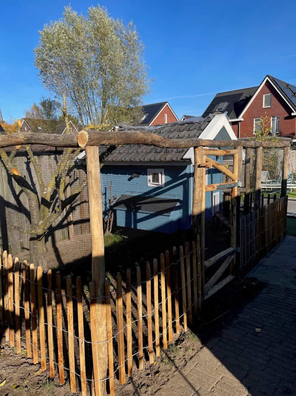 Robinia schapenhek van 80 cm en een latafstand van 8 cm hoog met een latafstand van 8 cm met een raamwerkpoort van 80 cm breed bij 80 cm hoog en robinia palen diam. 8/10 van 250 cm lang bij een kippenhok.