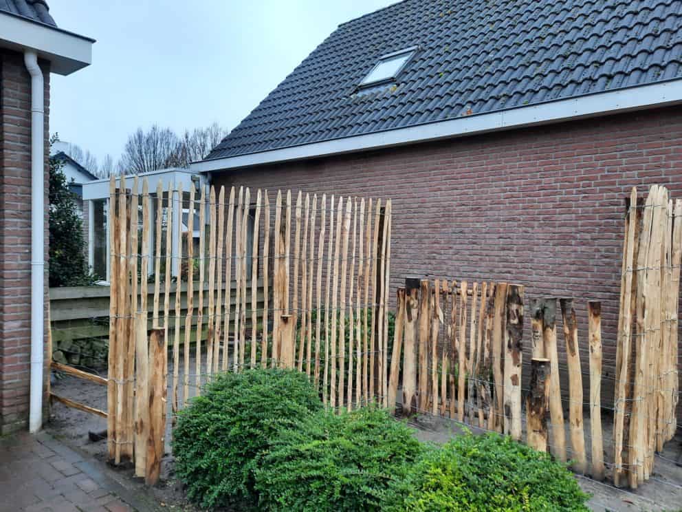 Frans schapenhek kastanje 200 hoog, latafstand 4 cm en een Franse rondhoutpoort van 80 cm breed bij 210 cm hoog.