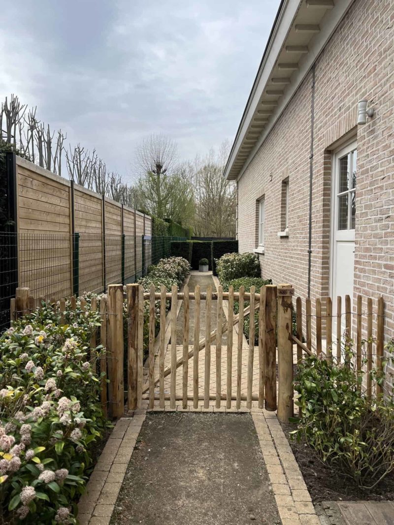 Robinia schapenhek 100 cm hoog, latafstand 4 cm met Franse rondhoutpoort 120 breed bij 100 cm hoog als toegangspoort tussen de woning en de omheining van de tuin.