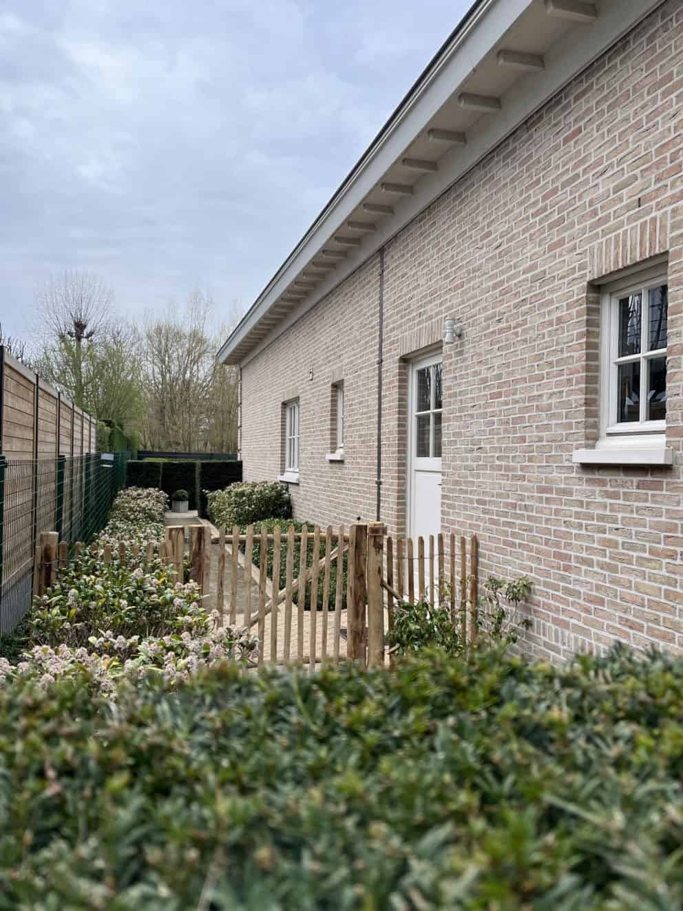 Robinia schapenhek 100 cm hoog, latafstand 4 cm met Franse rondhoutpoort 120 breed bij 100 cm hoog als toegangspoort tussen de woning en de omheining van de tuin.