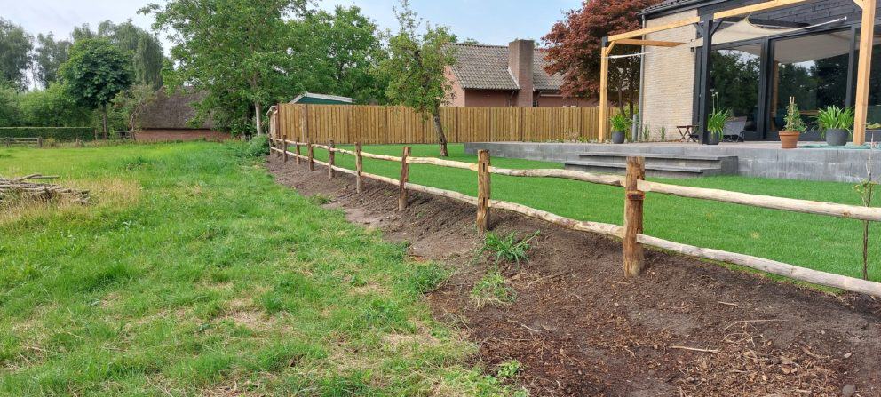 Post & rail niveau 2 rond met liggers als omheining in de tuin bij een huis.