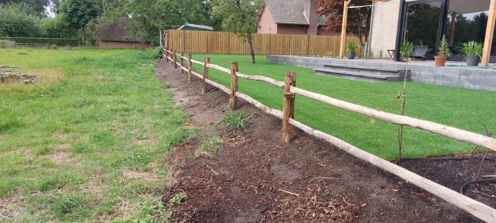 Post & rail niveau 2 rond met liggers als omheining in de tuin bij een huis.