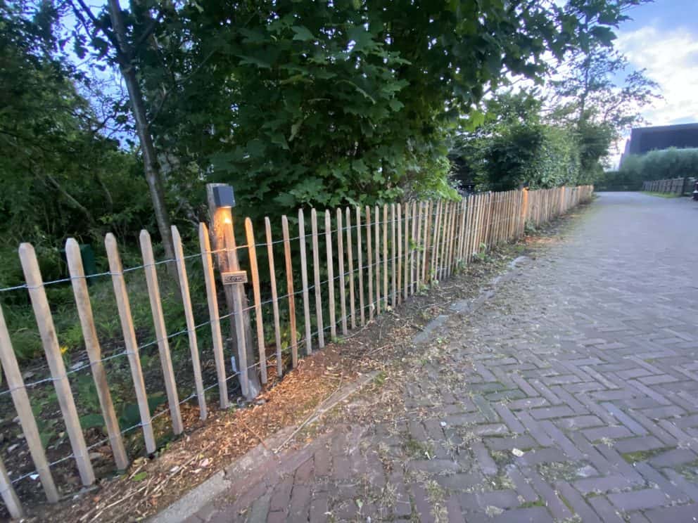 Robinia schapenhek geschuurd van 100 cm hoog met een latafstand van 8 cm met robinia palen van 160 cm lang met een diameter van 8/10 cm als afrastering bij een stuk groen.