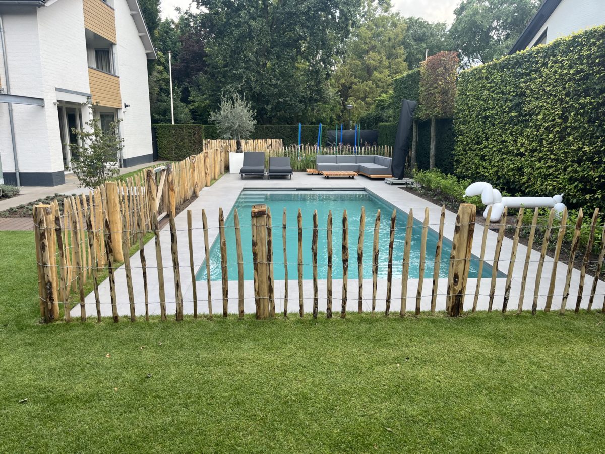 Frans kastanje schapenhek van 100 cm hoog met een latafstand van 10 cm met kastanje palen van 175 cm lang met een diameter van 10/12 cm gebruikt voor een omheining om een zwembad.