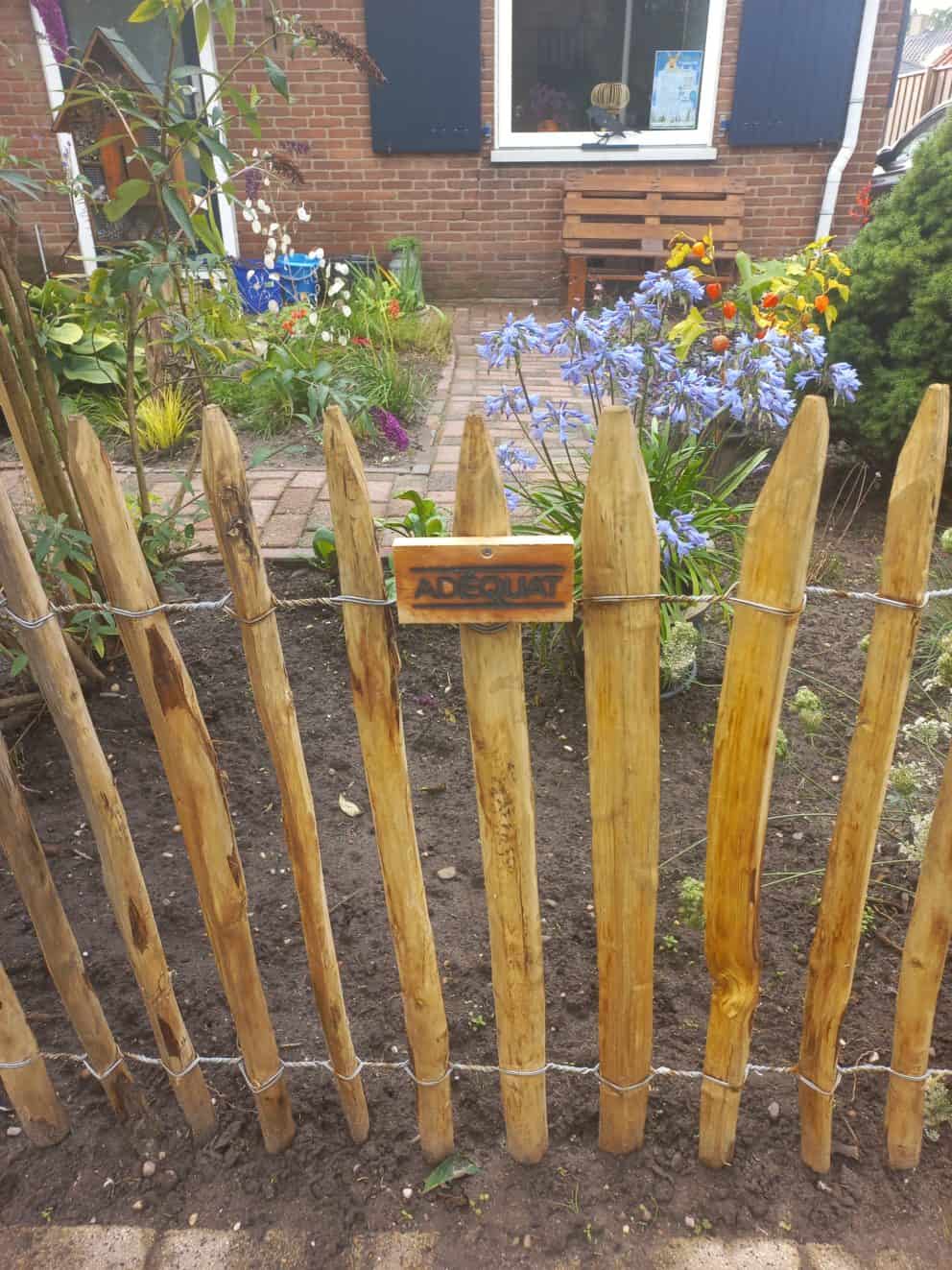 Frans schapenhek van kastanje van 80 cm hoog met een latafstand van 4 cm met kastanje palen van 125 cm lang en een diameter van 7-9 cm gebruikt als omheining in de voortuin