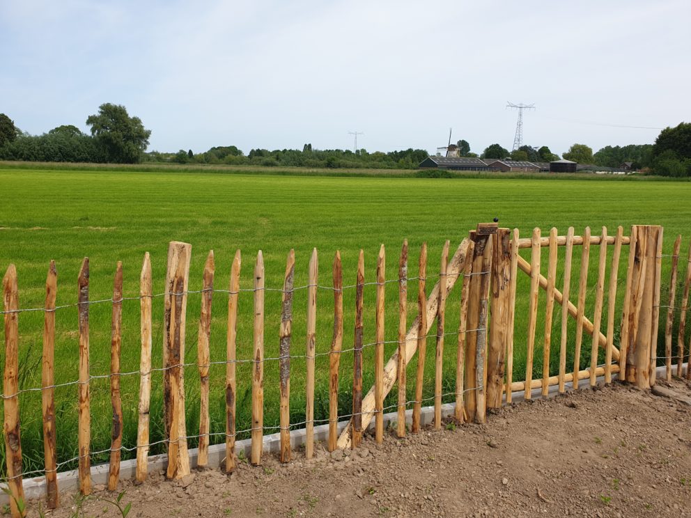 Rasterhekwerk 100 cm en een latafstand van 8 cm met en een rondhoutpoort van 120 cm breed en 100 cm hoogAdequat