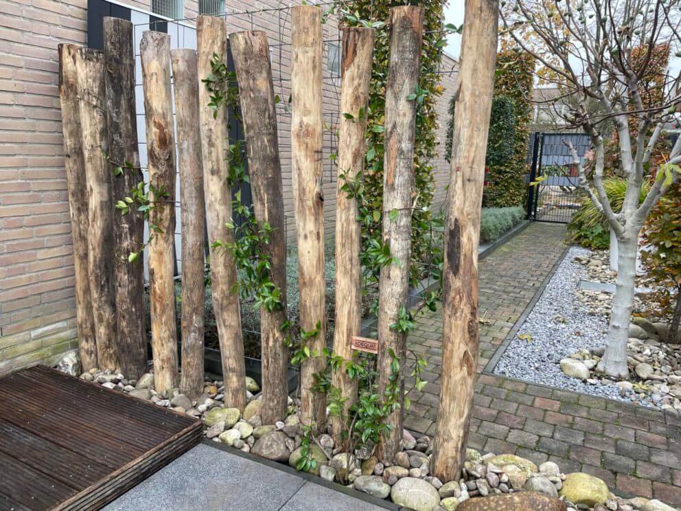 Creatieve afscheiding in de tuin met robinia palen van 250 cm lang en diameter 12/14 cm.