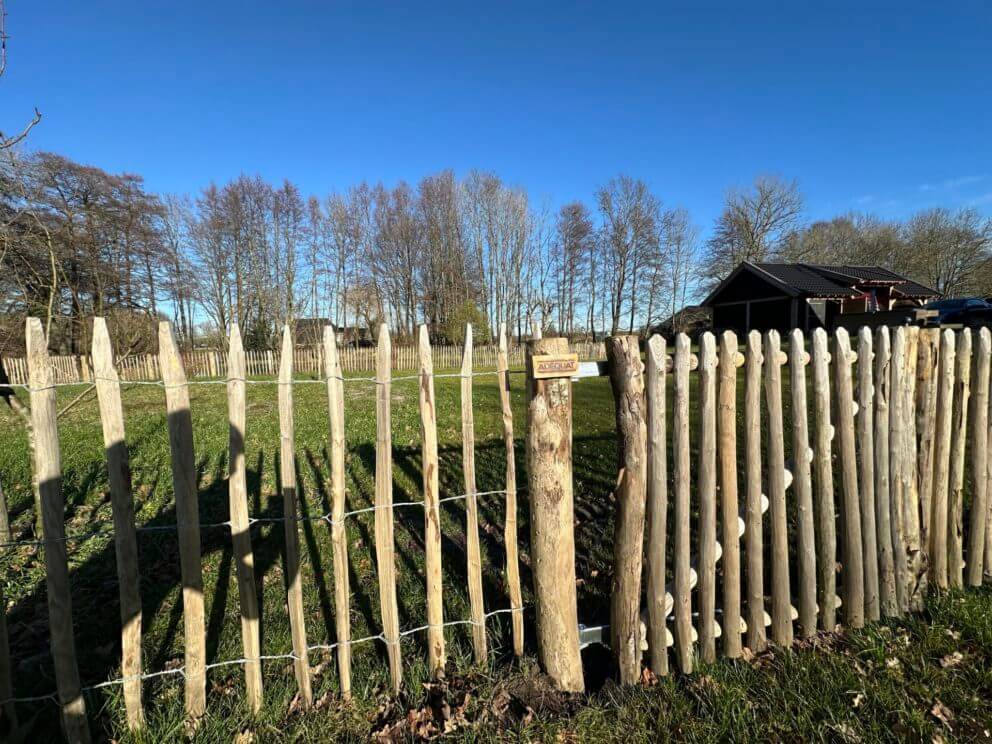 Frans schapenhek 100 cm hoog met latafstand 8 cm met een Franse rondhoutpoort van 100 cm breed bij 100 cm hoog en kastanje palen diameter 7-9 cm met een lengte van 175 cm.