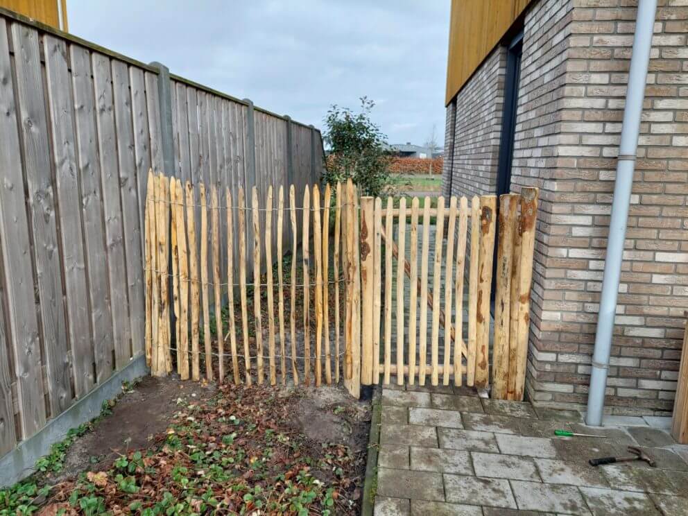 Frans schapenhek van 120 cm hoog, latafstand 4 cm met Franse rondhoutpoort van 80 breed bij 120 hoog en kastanje palen met een diameter van 7-9 cm en een lengte van 175 en 200 cm.