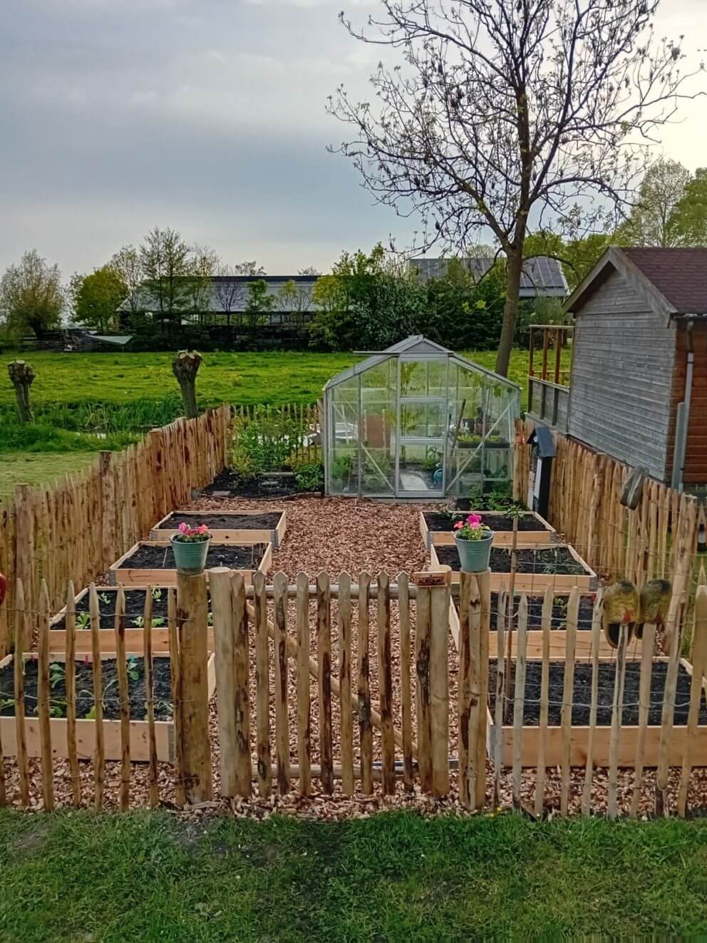 Franse enkele rondhoutpoort van 100 cm breed bij 100 cm hoog en Frans schapenhek van 100 cm hoog met een latafstand van 6 cm met robinia palen van 160 cm lang met een diameter van 8-10 cm