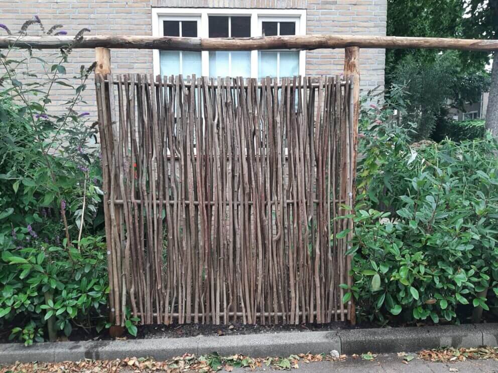 Creatieve afrastering in de voortuin van kastanje paal diam. 7/9 cm lengte 300 en 400 cm met kastanje paal 300 cm lang, diameter 10/12 cm met Hazelaar scherm Somme 180 (180 cm breed bij 180 cm hoog)