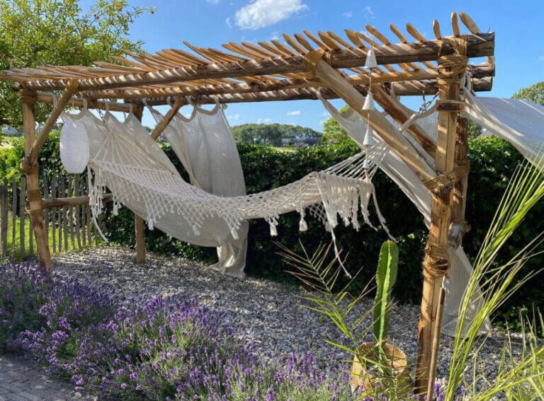 Pergola van kastanjehouten palen voor het ophangen een hangmat