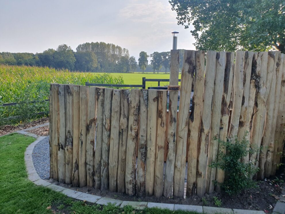 Windbreker bij de hottub gemaakt van kastanje palen 200 en 250 cm lang, diam. 10/12 cm