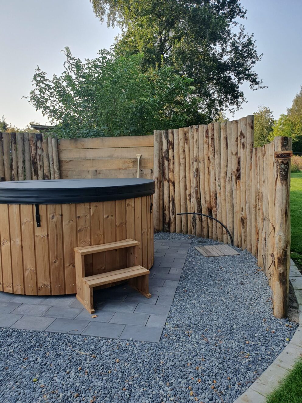 Windbreker bij de hottub gemaakt van kastanje palen 200 en 250 cm lang, diam. 10/12 cm en kastanje planken gezaagd 3x20x250 cm