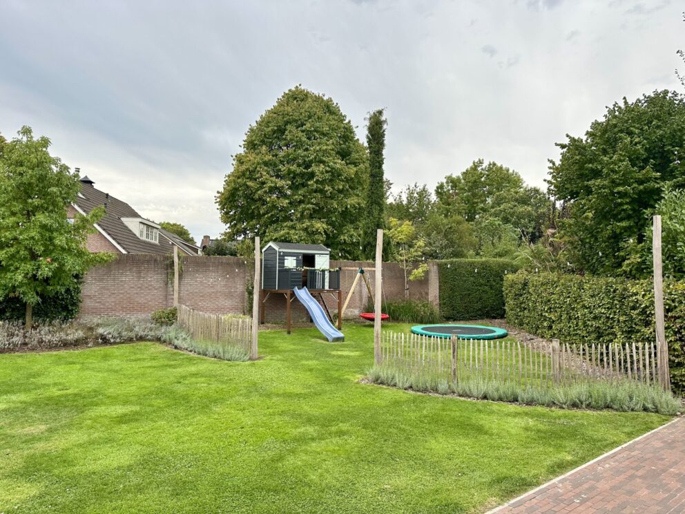 Omheining bij speeltuin gemaakt van Frans schapenhek 100 cm hoog, latafstand 4 cm met robinia palen 160 en 400 cm lang, diameter 10/12 cm met een lichtsnoer eraan.