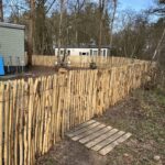 Schapenhek kastanje 120 cm hoog, latafstand 2 cm met robinia palen 200 cm lang, diameter 8/10 en 10/12 cm met een schapenhek poort 120Bx120H (cm) en een kastanje looppad.