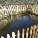 Vijver omheining van robinia schapenhek 100 cm hoog, latafstand 4 cm met kastanje paal 150/160 en 175 cm lang, diameter 7/9 cm