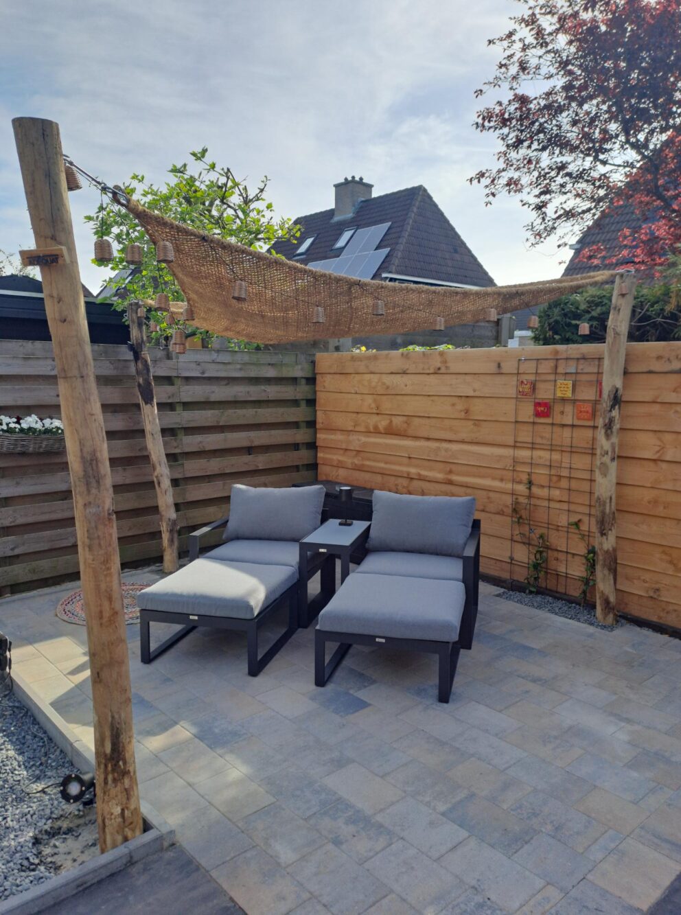 Zithoek in de tuin met schaduwdoek, bevestigd aan robinia paal 300 cm lang, diameter 10-12 cm, geschild gepunt