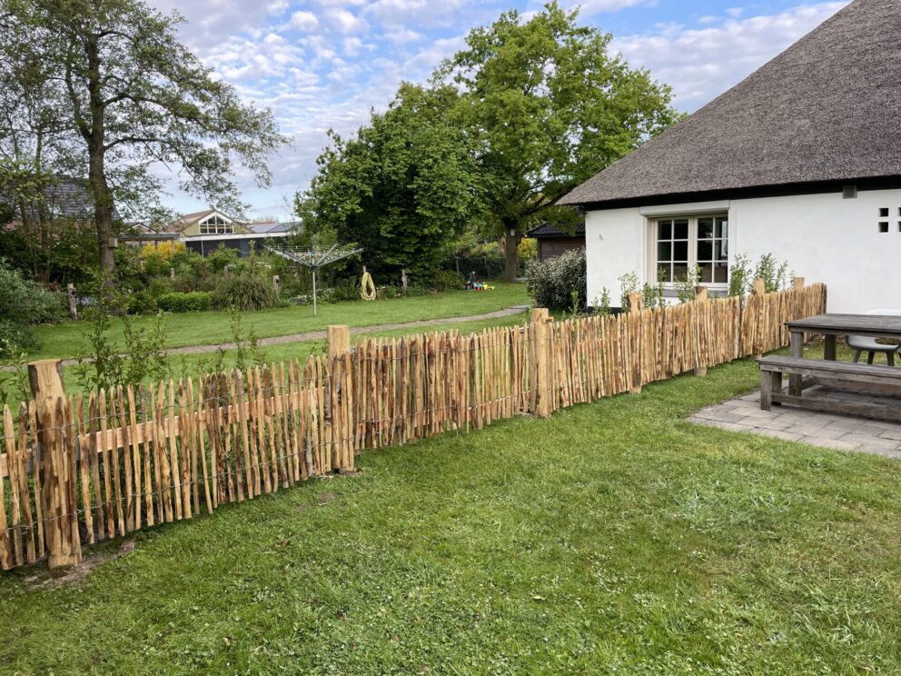Landelijk modern huis met Frans schapenhek kastanje 80 hoog, latafstand 2 cm 2 x5m rol en Kastanje paal 175 cm lang, diameter 13-16 cm, gepunt