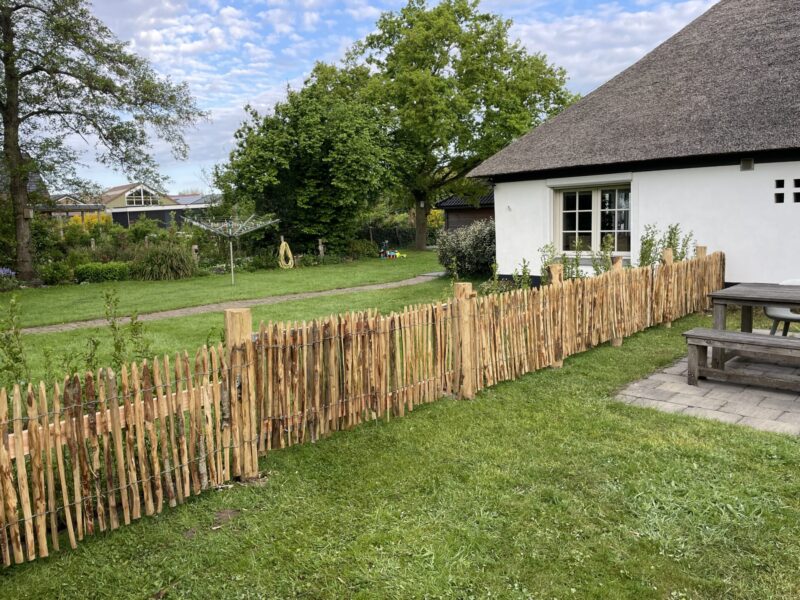 Landelijk modern huis met Frans schapenhek kastanje 80 hoog, latafstand 2 cm 2 x5m rol en Kastanje paal 175 cm lang, diameter 13-16 cm, gepunt