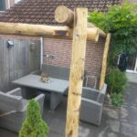 Pergola rondom de zithoek in de tuin gemaakt van kastanje paal 300 en 350 cm lang, diameter 10/12 cm