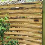 Vlechtscherm kastanje 180 cm breed bij 180 cm hoog met beplanting in een achtertuin.